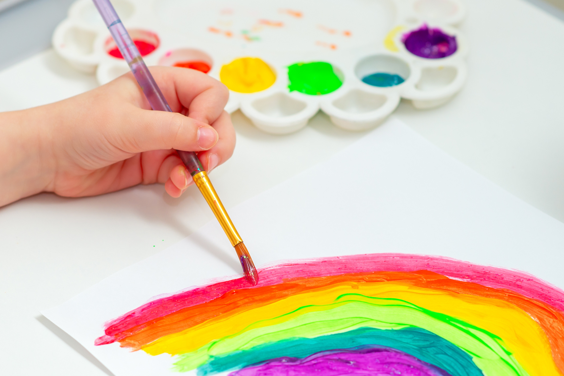 Kid painting rainbow during quarantine.